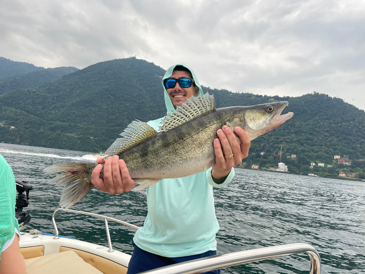 A lake como fishing guided fishing customer catching and releasing a Zander